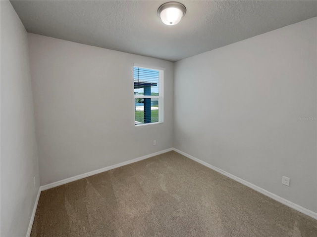 carpeted spare room featuring a textured ceiling