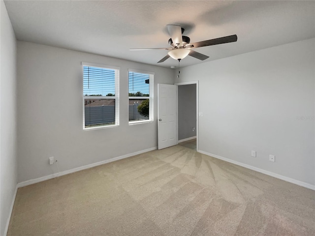 spare room featuring light carpet and ceiling fan