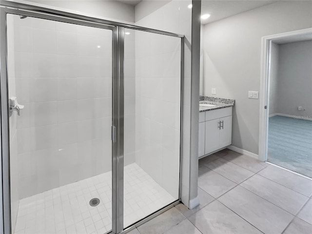 bathroom with vanity, tile floors, and a shower with shower door