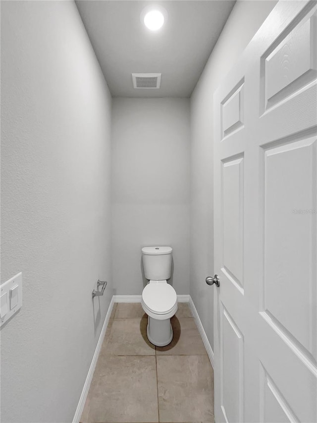 bathroom featuring tile floors and toilet