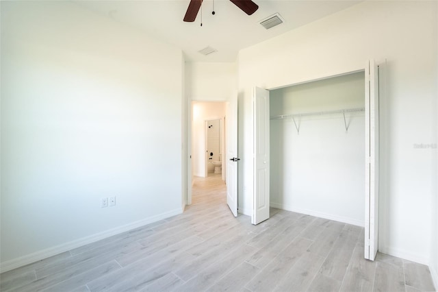 unfurnished bedroom with ceiling fan, light wood-type flooring, and a closet