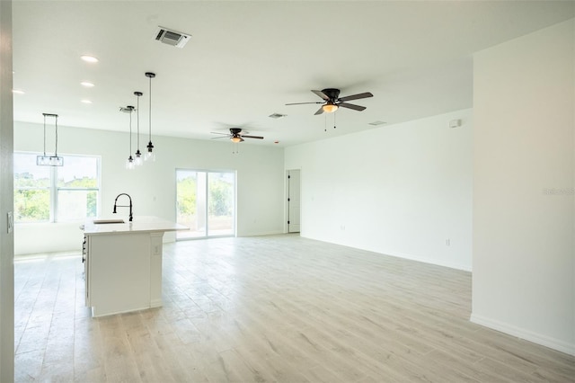 interior space with ceiling fan, sink, and light hardwood / wood-style floors