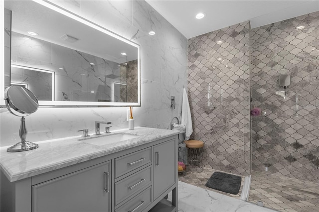 bathroom with tile walls, vanity, tile floors, and tiled shower