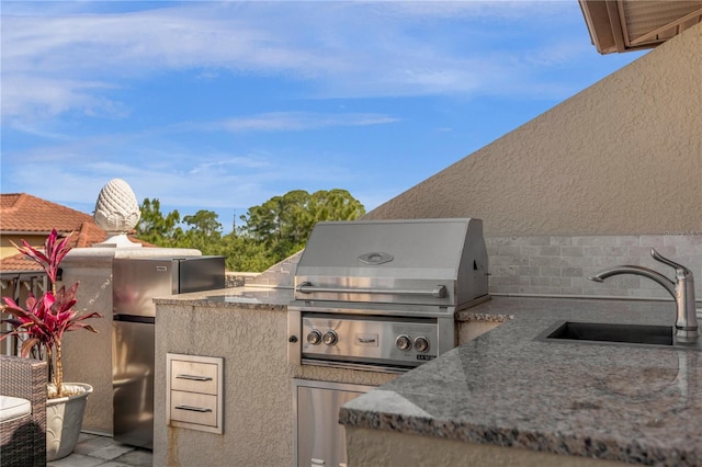 view of patio / terrace with grilling area, sink, and an outdoor kitchen