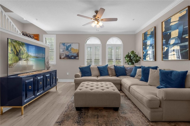 living room with a healthy amount of sunlight, ceiling fan, light wood-type flooring, and ornamental molding