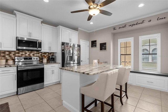 kitchen featuring appliances with stainless steel finishes, backsplash, ceiling fan, and white cabinetry