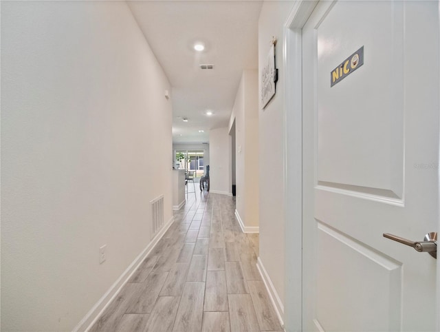 hallway with light hardwood / wood-style floors