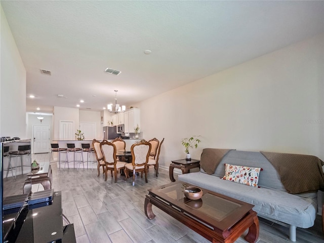 living room with a chandelier and light hardwood / wood-style flooring