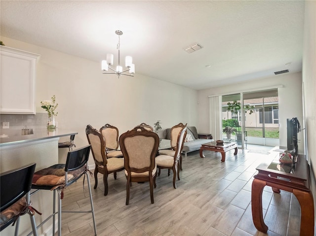 dining area featuring light hardwood / wood-style flooring and an inviting chandelier