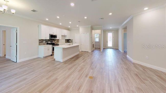 kitchen with tasteful backsplash, a center island with sink, stainless steel appliances, light hardwood / wood-style floors, and white cabinets