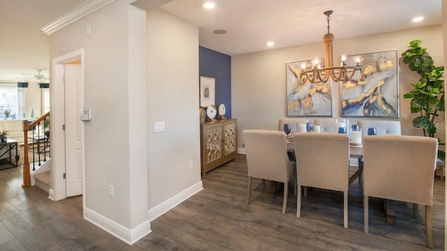 dining space with dark wood-type flooring, ornamental molding, and an inviting chandelier