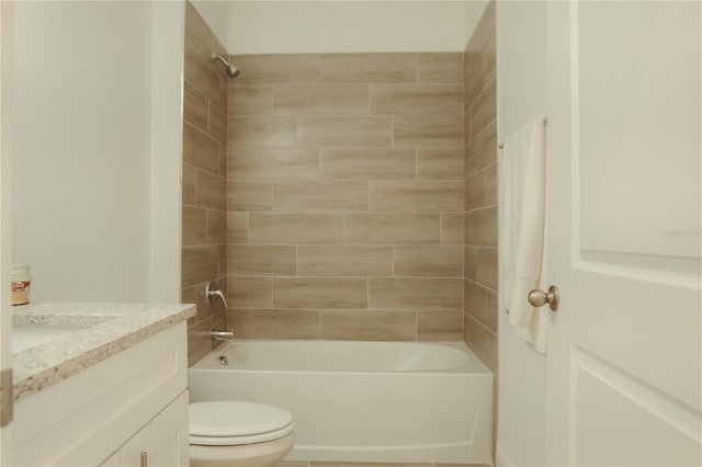 full bathroom featuring tiled shower / bath, vanity, and toilet