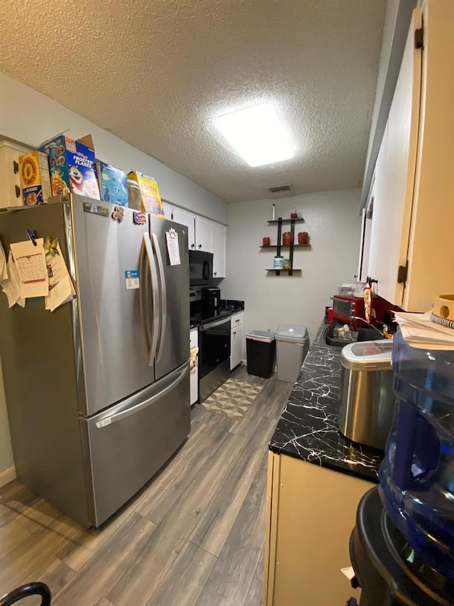 kitchen featuring white cabinets, dark hardwood / wood-style flooring, appliances with stainless steel finishes, sink, and a textured ceiling