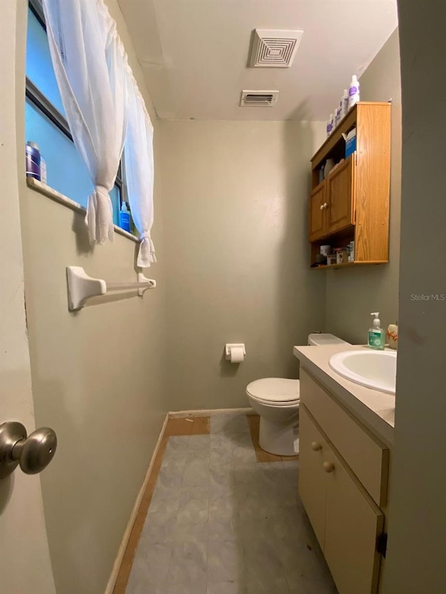 bathroom with tile flooring, vanity, and toilet