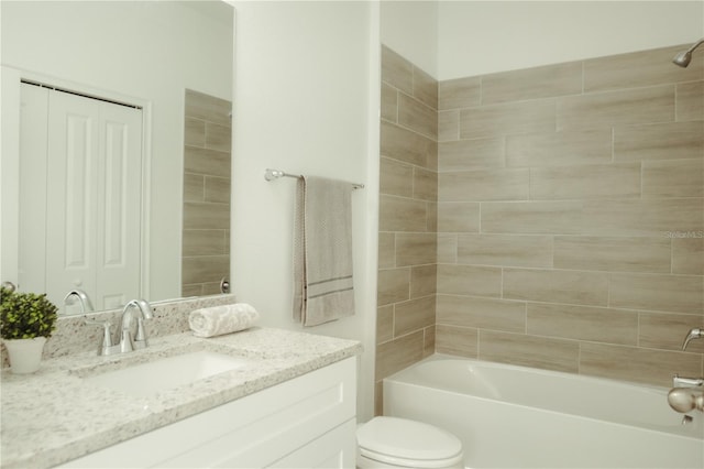 full bathroom featuring toilet, vanity with extensive cabinet space, and tiled shower / bath