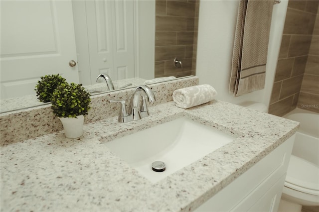 bathroom featuring vanity with extensive cabinet space and toilet