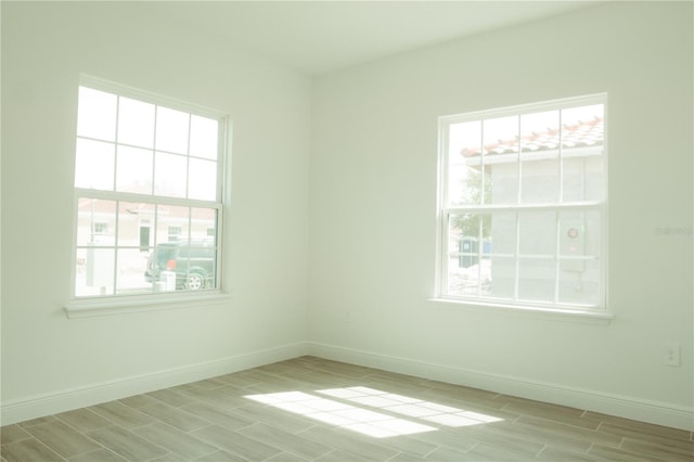 empty room featuring a healthy amount of sunlight and light hardwood / wood-style floors