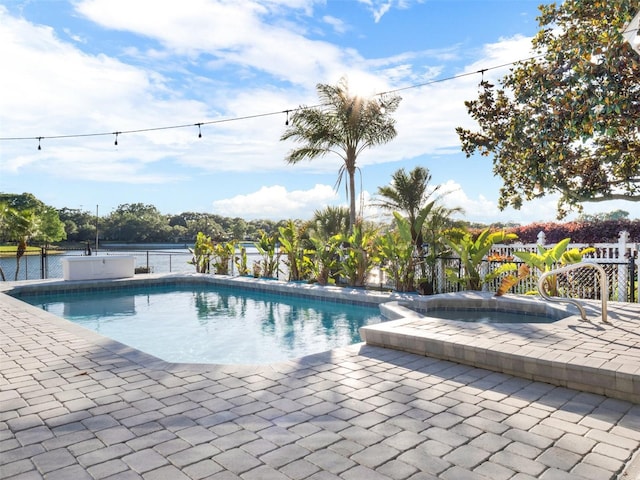 view of pool featuring a water view, an in ground hot tub, and a patio