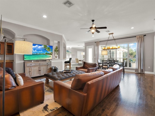 living room with crown molding, dark hardwood / wood-style floors, and ceiling fan with notable chandelier