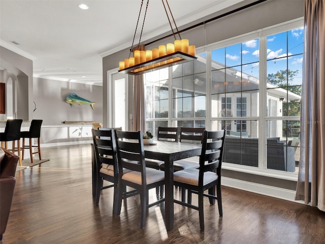 dining area featuring dark hardwood / wood-style floors, crown molding, and a wealth of natural light