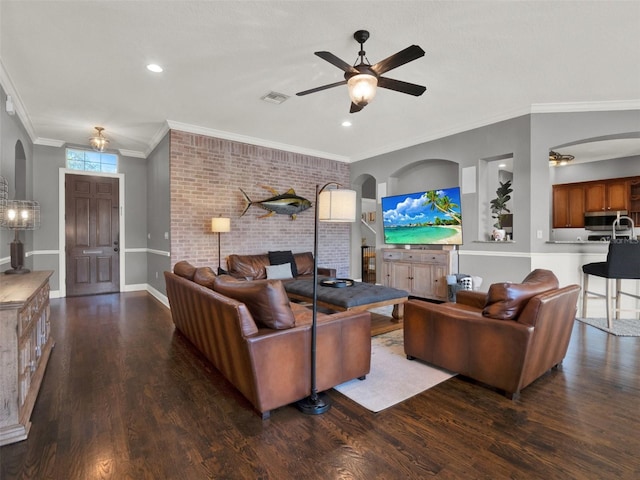 living room featuring ceiling fan, ornamental molding, brick wall, and wood-type flooring