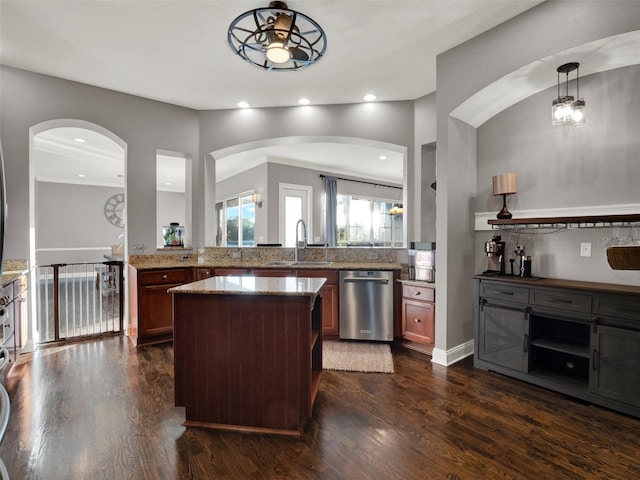 kitchen featuring pendant lighting, sink, stainless steel dishwasher, dark hardwood / wood-style floors, and light stone counters