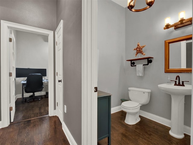 bathroom with toilet, wood-type flooring, and sink