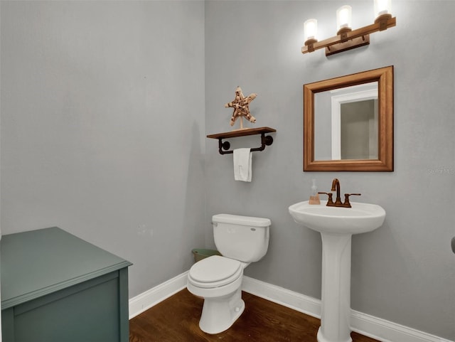 bathroom featuring wood-type flooring, toilet, and sink