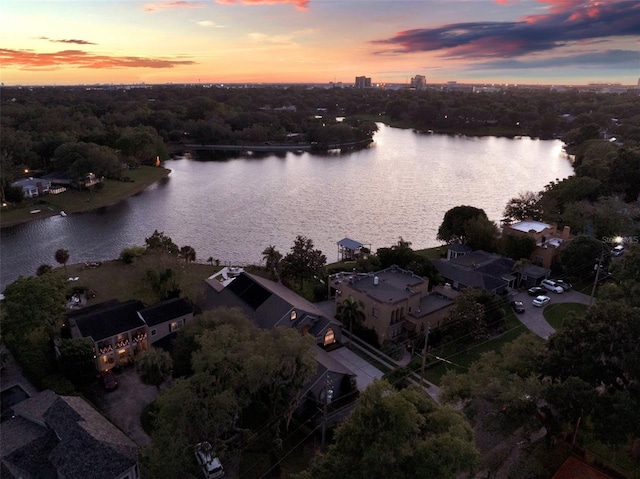 aerial view at dusk featuring a water view