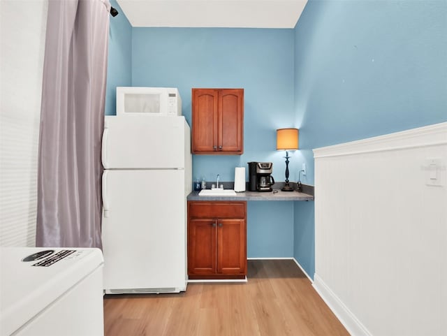 kitchen featuring white appliances, light hardwood / wood-style flooring, and sink