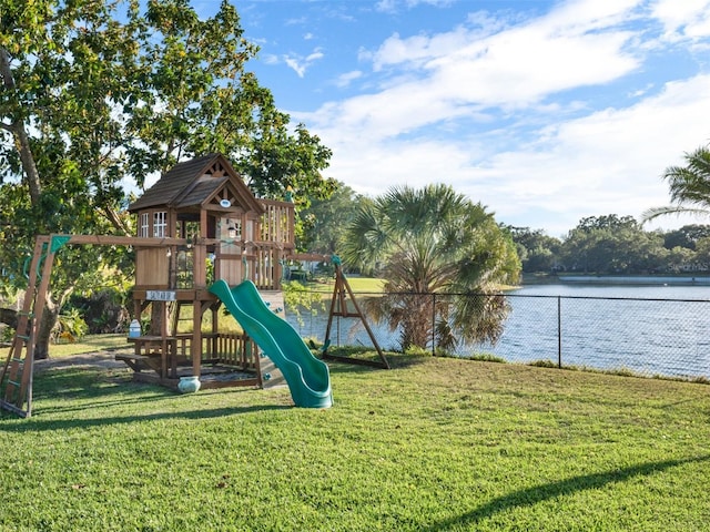 view of jungle gym featuring a lawn and a water view