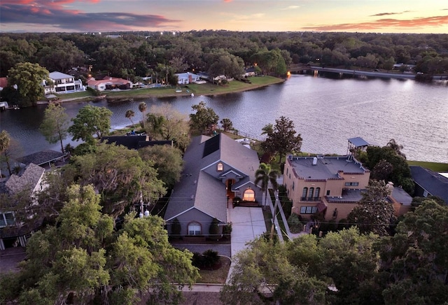 aerial view at dusk featuring a water view