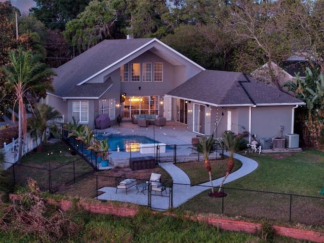 rear view of house featuring outdoor lounge area, a yard, central air condition unit, a fenced in pool, and a patio