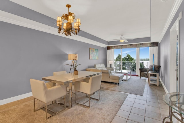 tiled dining room featuring ceiling fan with notable chandelier, a tray ceiling, and ornamental molding