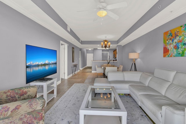 living room featuring a tray ceiling, light tile patterned flooring, and ceiling fan with notable chandelier