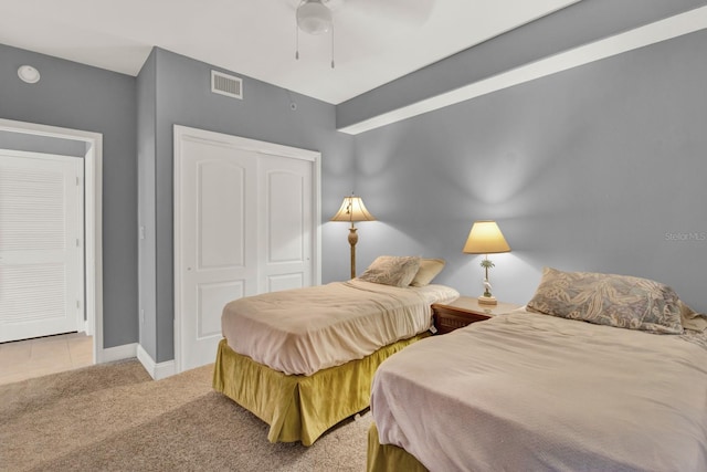 bedroom featuring ceiling fan, light carpet, and a closet