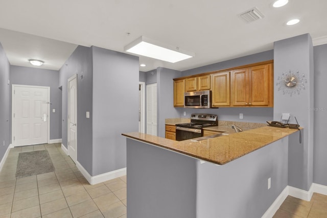 kitchen featuring sink, light tile patterned floors, appliances with stainless steel finishes, light stone counters, and kitchen peninsula