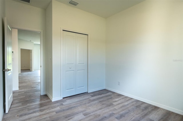 unfurnished bedroom with a closet and hardwood / wood-style floors