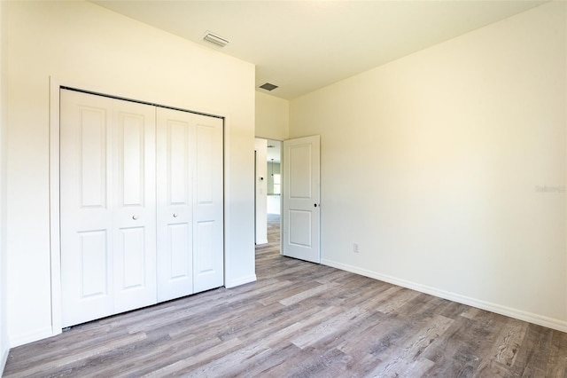 unfurnished bedroom featuring a closet and hardwood / wood-style flooring