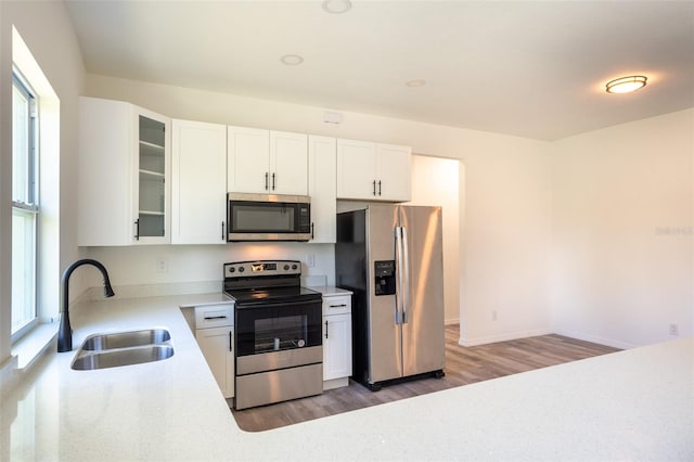 kitchen featuring sink, white cabinets, hardwood / wood-style floors, and stainless steel appliances