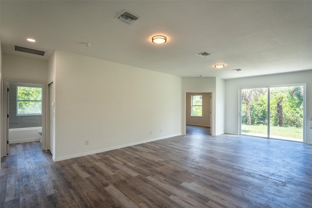 spare room with a wealth of natural light and dark hardwood / wood-style floors