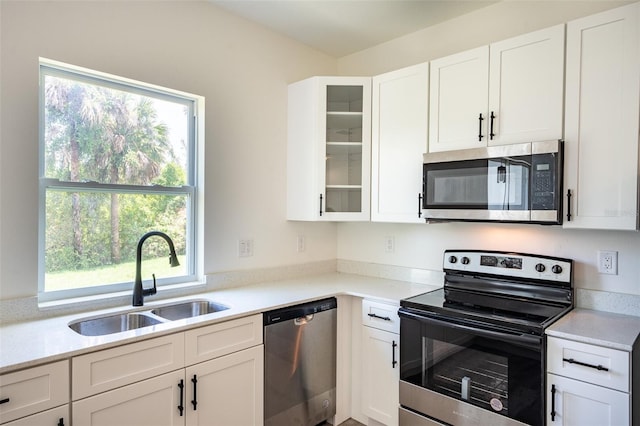 kitchen featuring white cabinets, appliances with stainless steel finishes, sink, and plenty of natural light