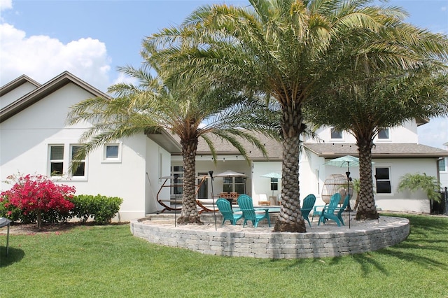 back of property with a lawn and a patio area