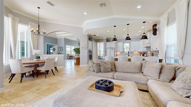 tiled living room featuring crown molding, an inviting chandelier, and a healthy amount of sunlight