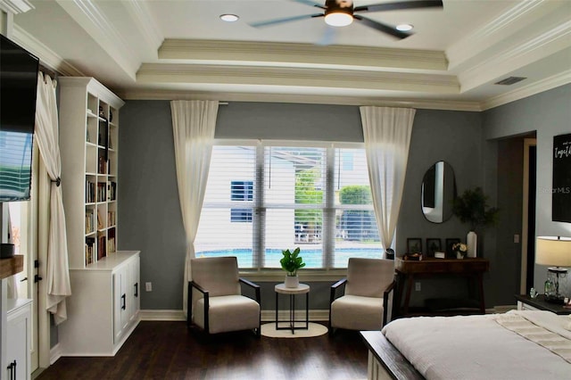 bedroom with ceiling fan, a raised ceiling, dark wood-type flooring, and ornamental molding