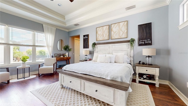 bedroom with ceiling fan, dark wood-type flooring, a tray ceiling, and crown molding