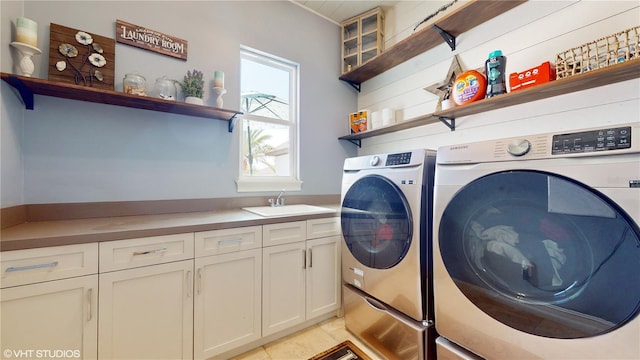 washroom featuring light tile floors, cabinets, separate washer and dryer, and sink