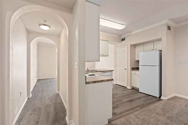 hall with dark carpet, sink, crown molding, and a textured ceiling