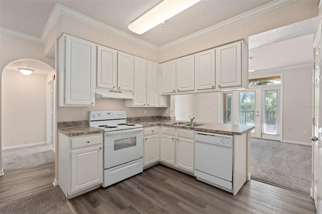 kitchen with white appliances, crown molding, white cabinets, and kitchen peninsula