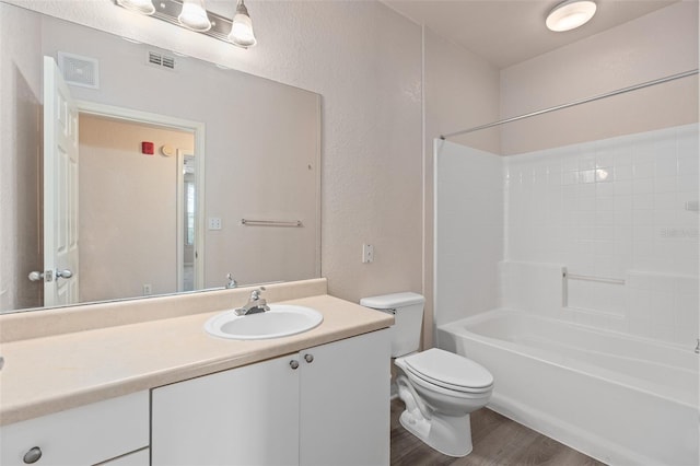 full bathroom with wood-type flooring, shower / washtub combination, vanity, and toilet